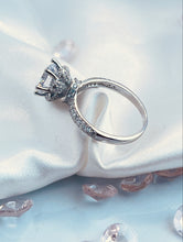Load image into Gallery viewer, The timeless six-prong setting offers a flawlessly engineered facet to the head of the ring that radiates a stunning reflection comparable to one of the world’s most expensive diamonds. Lined along the upper shank are cubic zirconia accents stones, pointing your attention back to the glorious head. Material: 925 Sterling Silver, Cubic Zirconia Design: Classic Weight: 2.9g