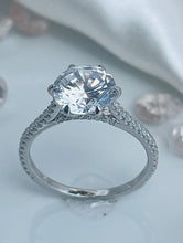 Load image into Gallery viewer, The stunning slender shank is balanced by the large brilliant round zirconia stone head that radiates light comparable to an expensive diamond. Offering a bold and sophisticated look are the cubic zirconia accent stones lined perfectly to lead the eyes to the head of the ring. Material: 925 Sterling Silver, Cubic Zirconia Design: Luxurious Weight: 2.8g.