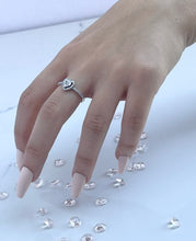 Load image into Gallery viewer, Three slim prongs surrounded by scintillating cubic zirconia stones form a heart-shaped head. This ring is a tangible representation of love and its many beautiful facets. The piece features a slender silhouette that is ideal for the woman who is never afraid to stand out through her unique personality. Material: 925 Sterling Silver, Cubic Zirconia Design: Heart Weight: 2.10g
